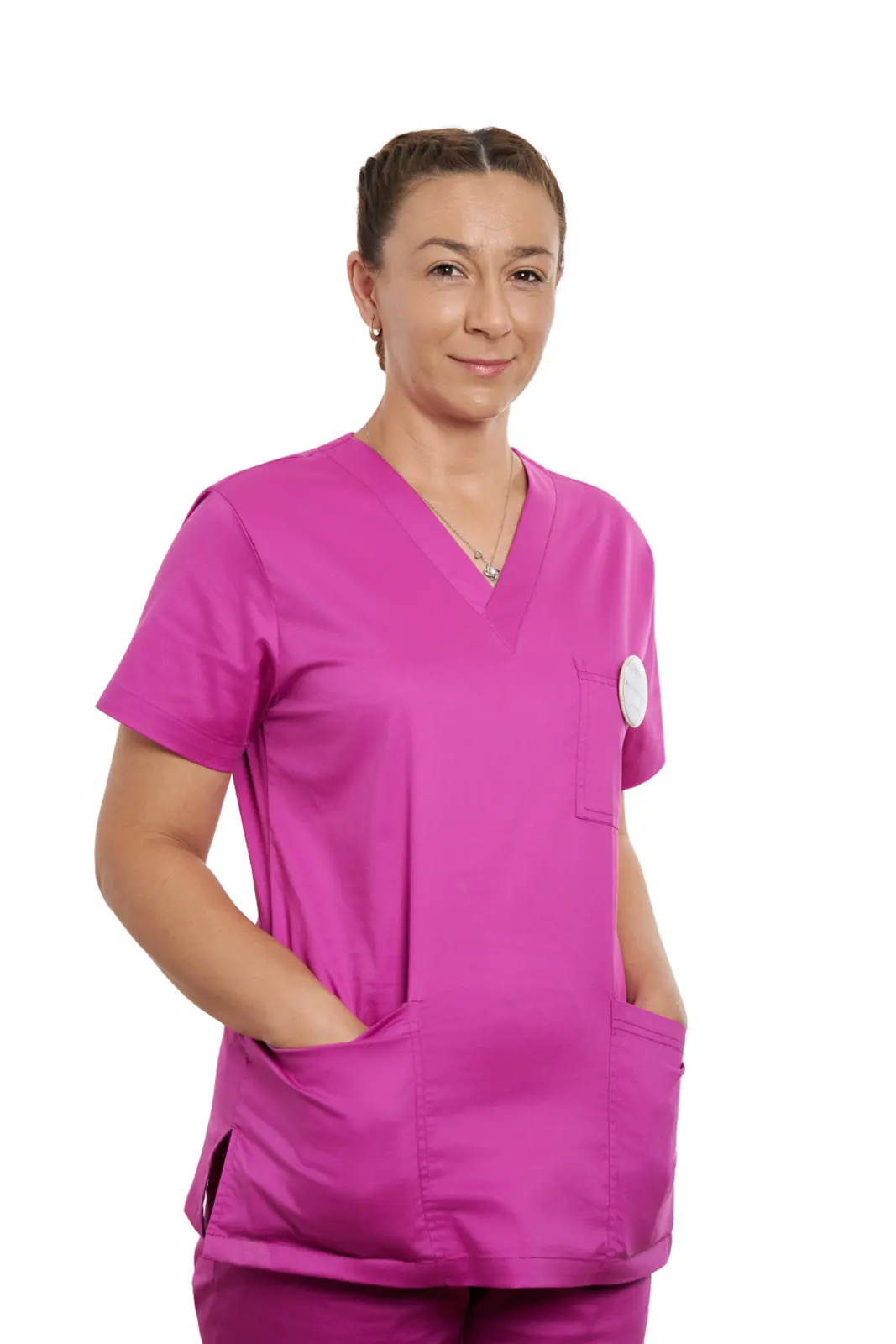 Asistentă medicală în uniformă roz magenta, zâmbind, cu mâinile în buzunare, AsertivO Otopeni