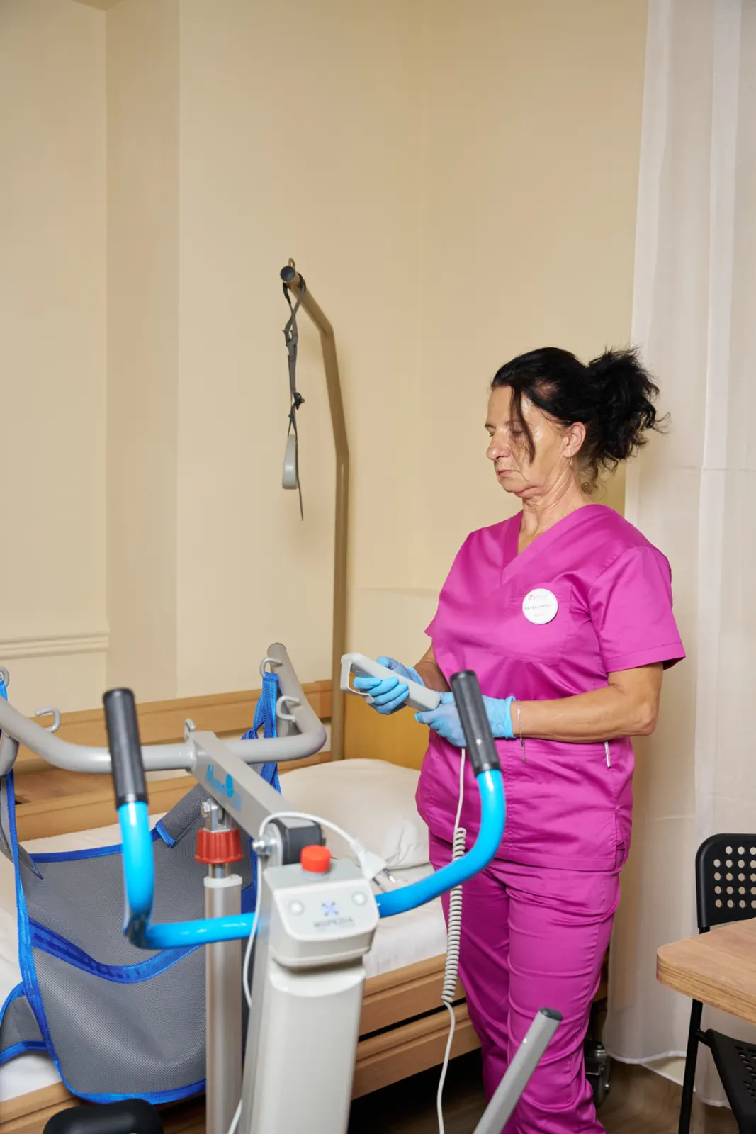 Asistentă medicală în uniformă roz cu mănuși albastre, AsertivO Otopeni