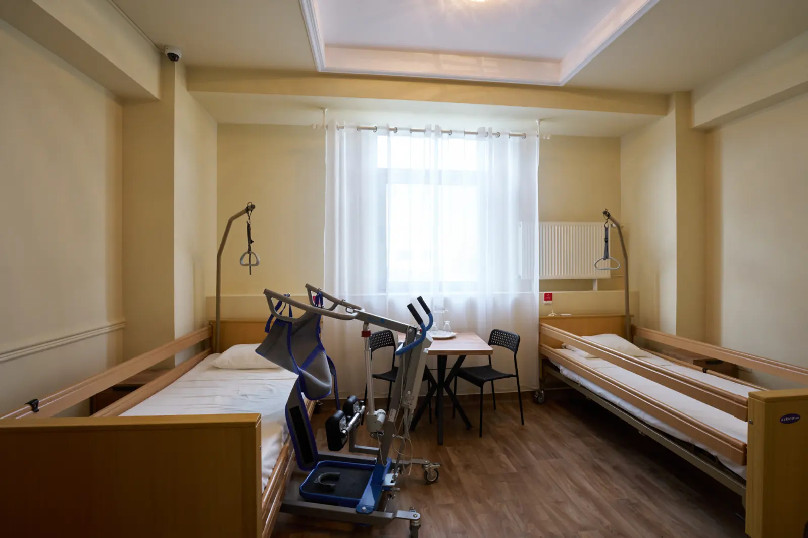 Cameră dublă într-un centru de îngrijire pentru seniori, cu două saltele medicale reglabile din lemn, AsertivO Otopeni