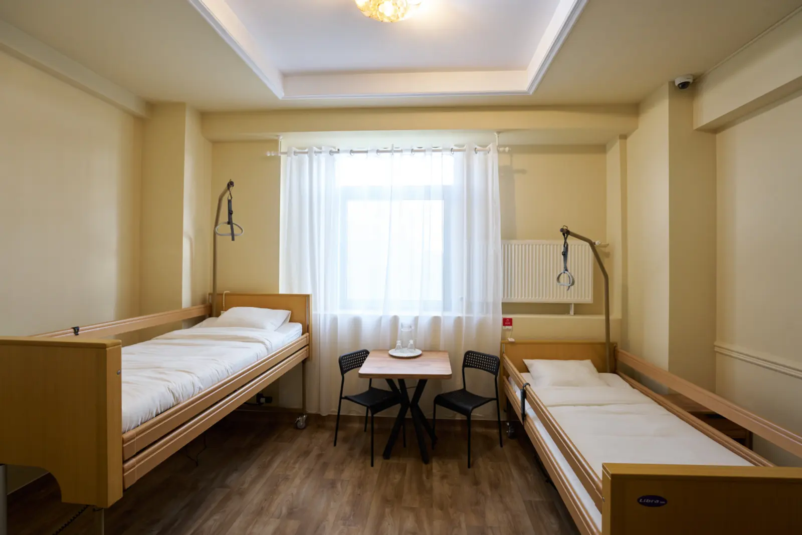 Cameră dublă într-un centru de îngrijire seniori din România, cu două saltele medicale din lemn, AsertivO Otopeni