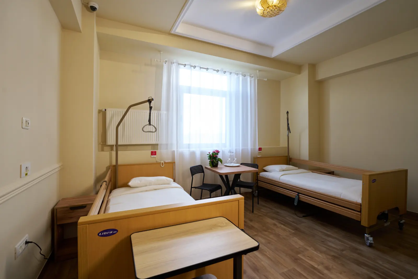 Cameră dublă dintr-un centru de îngrijire pentru seniori, cu două saltele medicale reglabile marca Libra, AsertivO Otopeni