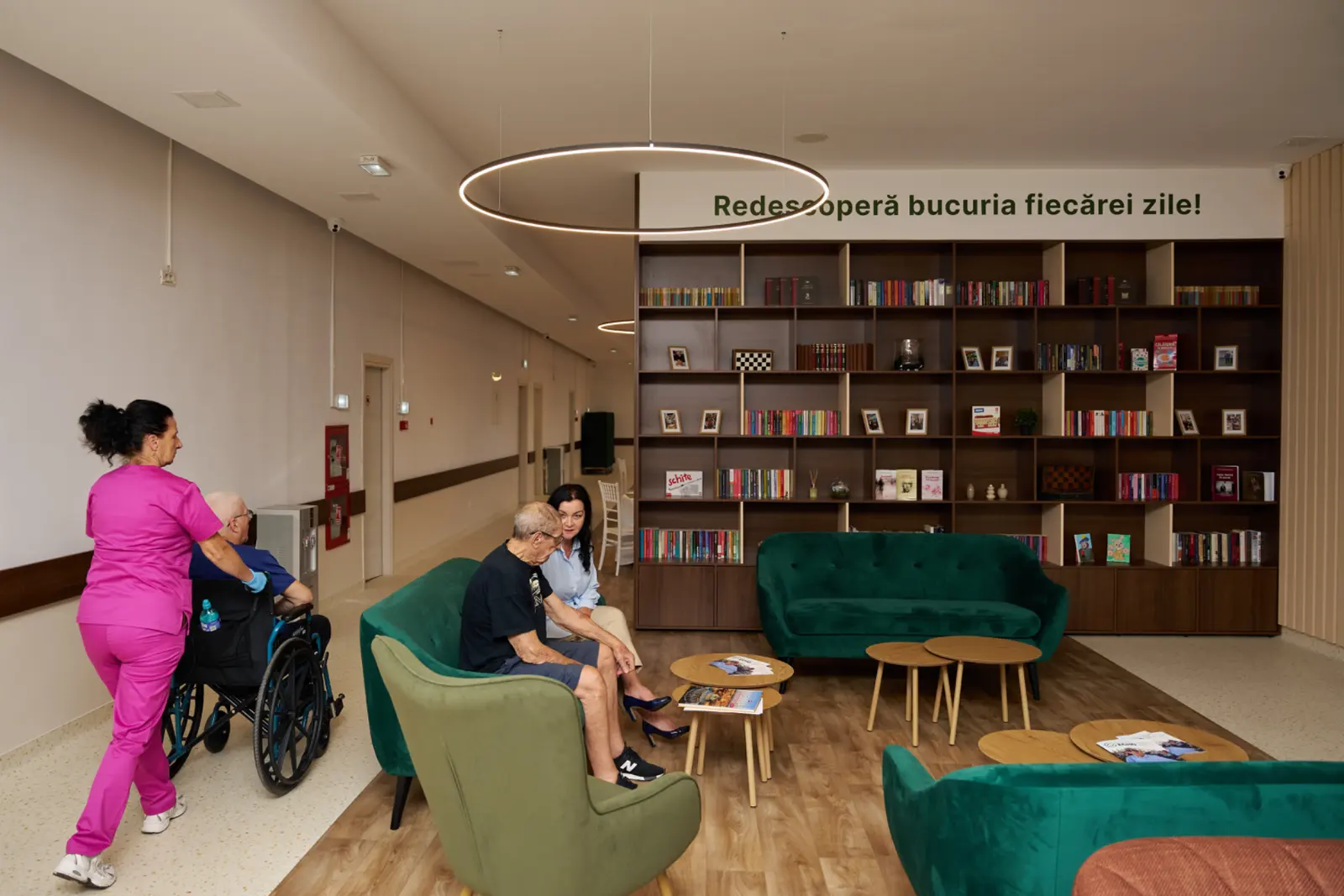 Cameră de relaxare dintr-un centru de îngrijire pentru seniori din România, cu o bibliotecă mare din lemn, AsertivO Otopeni