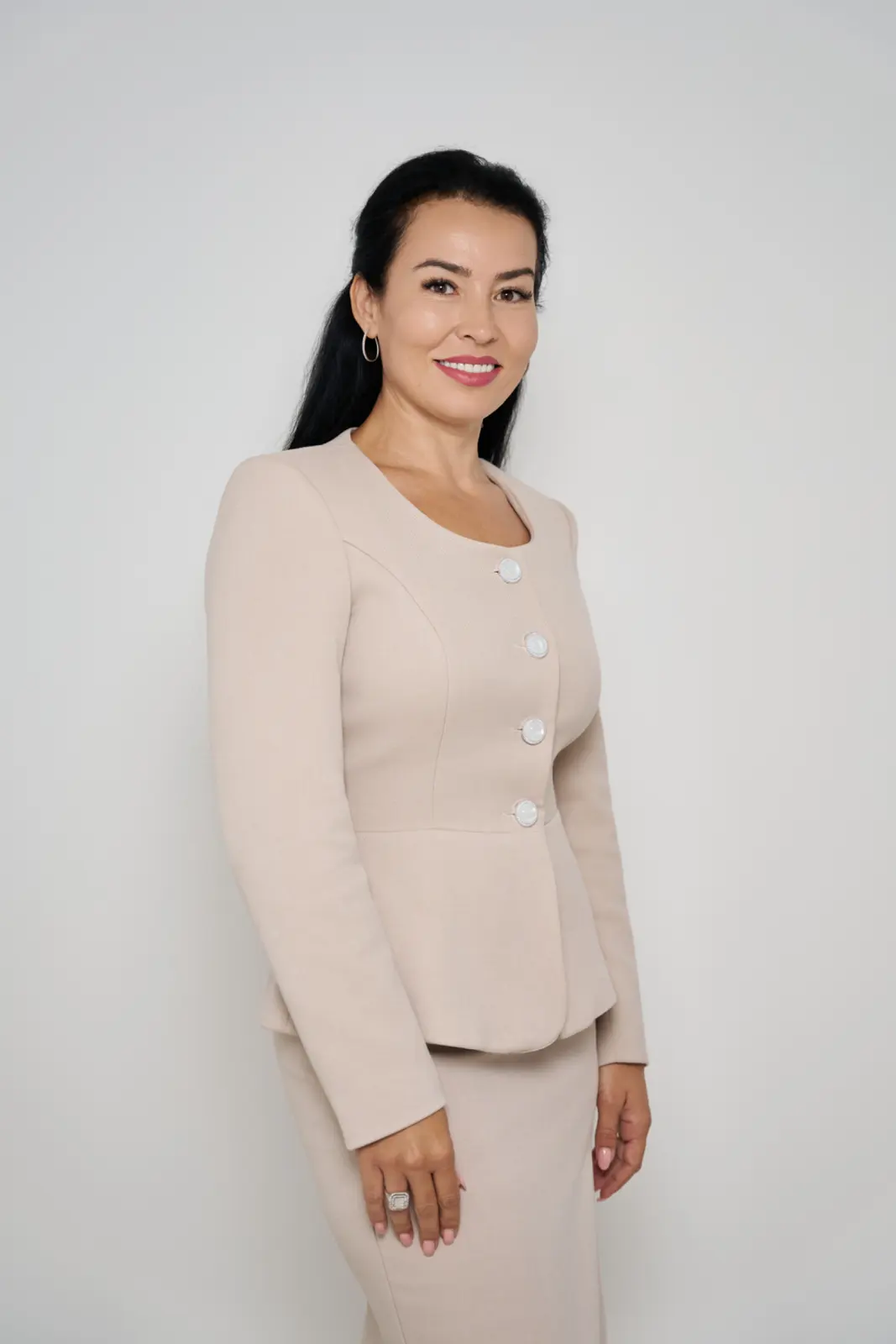 Femeie zâmbitoare în costum bej elegant, membră a echipei de îngrijire pentru seniori, AsertivO Otopeni