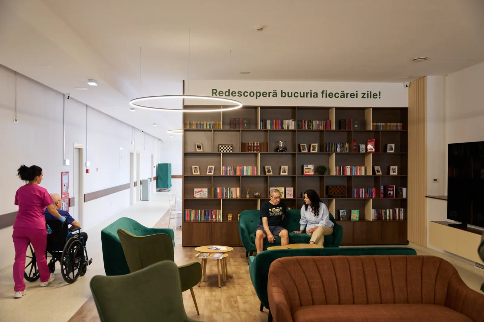 Sală de relaxare modernă într-un centru de îngrijire seniori, cu bibliotecă mare din lemn, AsertivO Otopeni