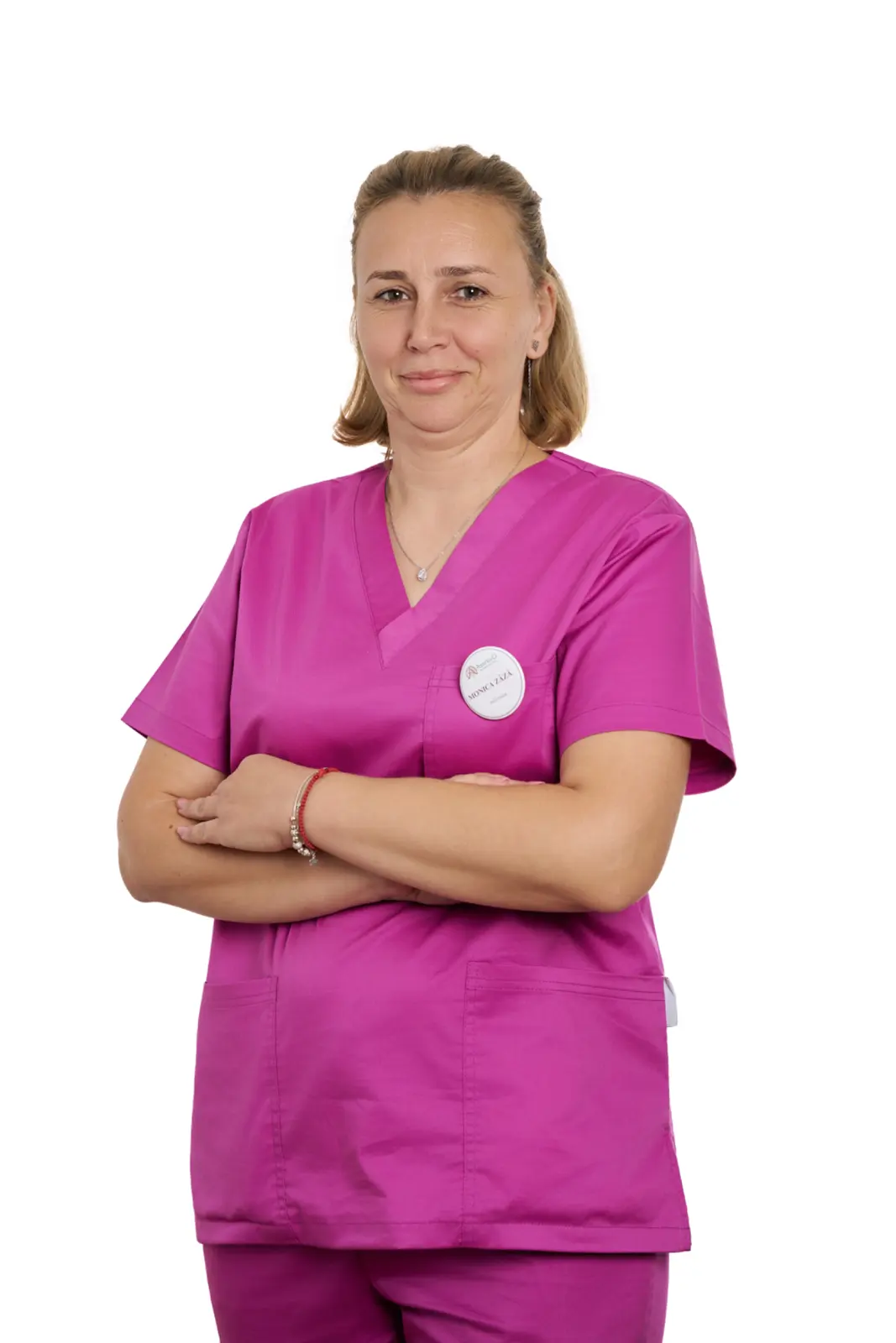 Asistentă medicală în uniformă roz, cu brațele încrucișate, zâmbind, AsertivO Otopeni