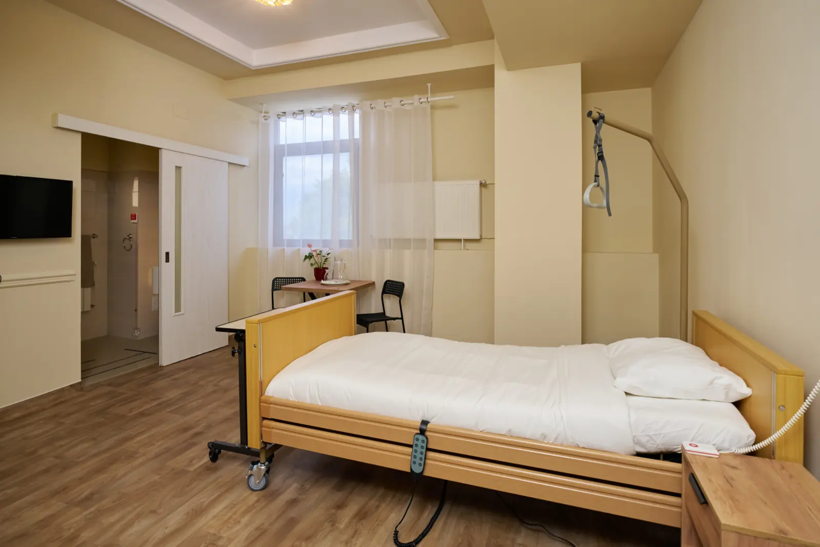 Cameră individuală luminoasă într-un centru de îngrijire seniori, cu saltea medical reglabil, AsertivO Otopeni