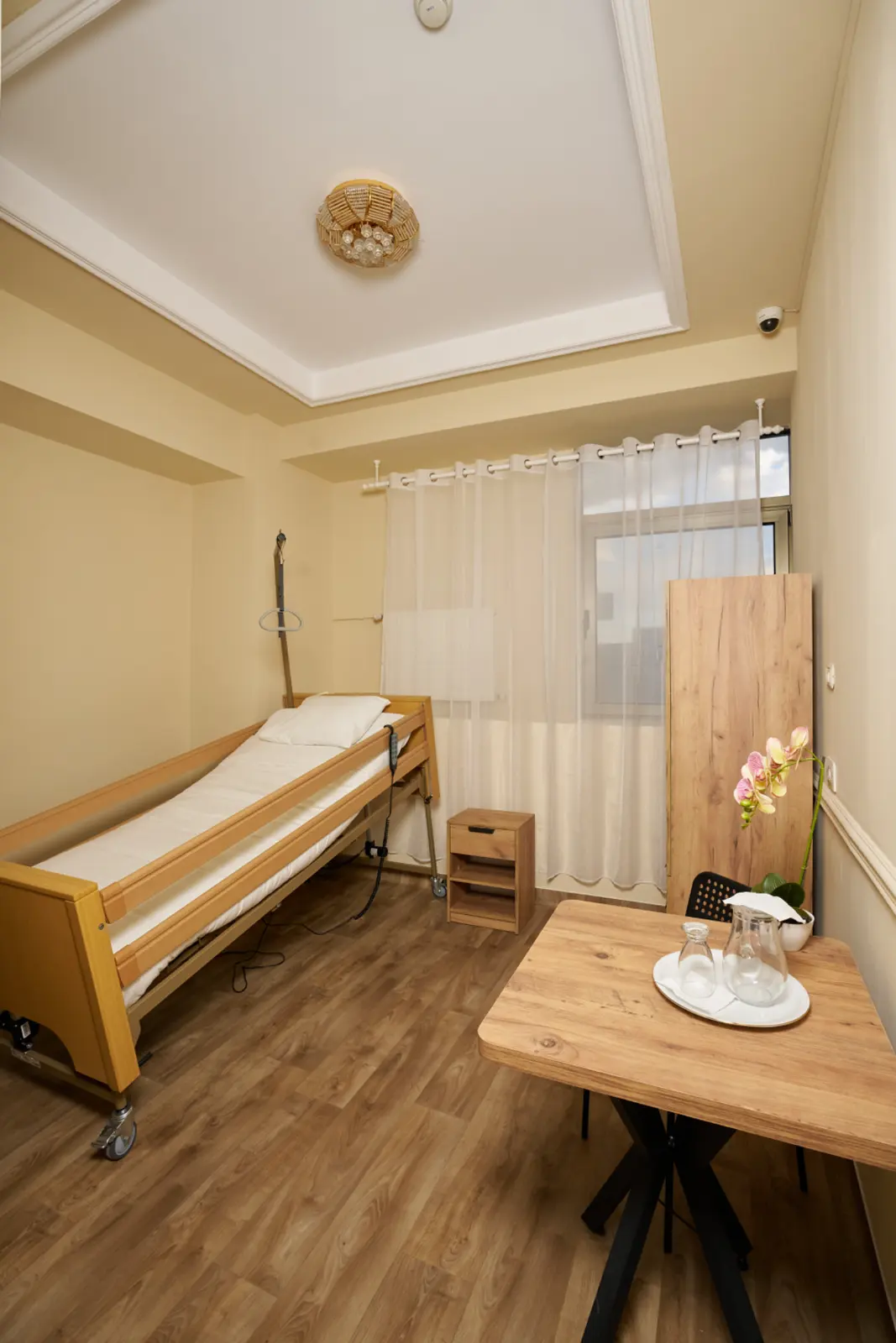 Cameră individuală luminoasă într-un centru de îngrijire seniori, cu saltea medical din lemn, AsertivO Otopeni