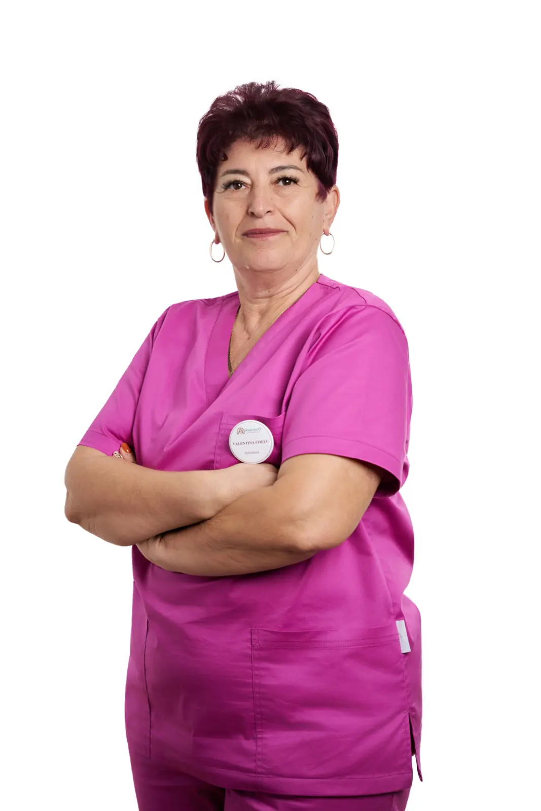 Infirmieră în uniformă roz, cu brațele încrucișate, portret profesional, AsertivO Otopeni